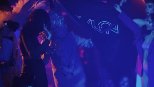 RUSSIA, KAZAN 20-02-2022: en man i en konstig kostym med stängt ansikte kommer ut bakom reklamflaggan i klubben — Stockvideo