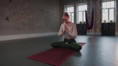 Hava yogası - bir kadın minderde yoga yapıyor.