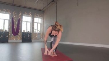 Kapalı alanda yoga yapan yetişkin bir plastik kadın stüdyoda aerobik yapıyor.