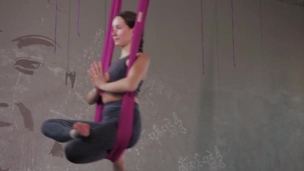 Aerial yoga - young woman does air yoga in an empty room — Stock video