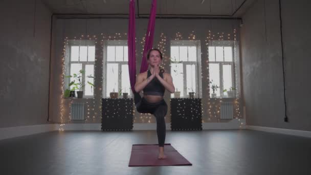 Повітряна йога - молода жінка робить йогу, використовуючи гамак — стокове відео