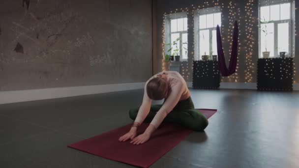 Yoga aéreo - uma mulher fazendo ioga no tapete no quarto vazio — Vídeo de Stock