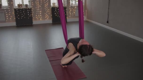 空中瑜伽- -一个年轻女子用粉色吊床伸展身体 — 图库视频影像