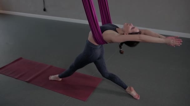Aerial yoga - a young woman doing yoga in pink hammock — Stock Video