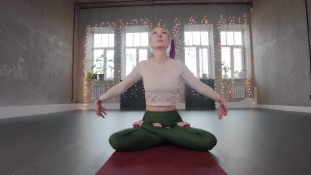 Yoga indoors - blonde woman meditating in the studio — Stockvideo