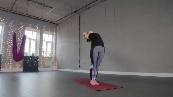 Yoga indoors - a plastic woman bends and wraps around her leg — Vídeos de Stock