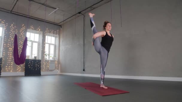 Yoga dentro de casa - uma mulher de plástico faz aeróbica no estúdio — Vídeo de Stock