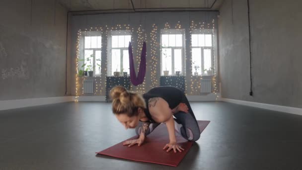 Yoga indoors - sports woman with tattoos doing aerobics in the studio — Stockvideo