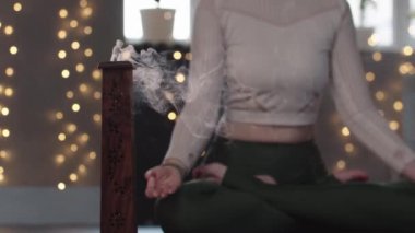 Stüdyoda tütsü ve meditasyon yapan bir kadın.