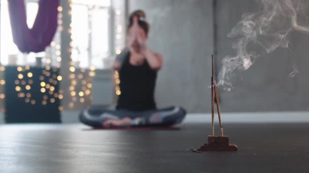 Parázsló tömjén a stúdióban - egy nő meditál a háttérben — Stock videók