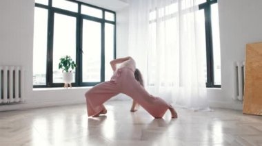 Sokak dansı - genç zayıf kadın beyaz odada dans ediyor
