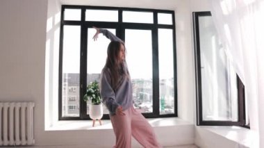 Sokak dansı - mavi kazaklı genç kadın geniş odada dans ediyor