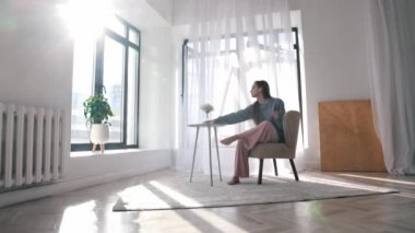 Modern dans. Genç bir kadın sandalyesinden kalkar ve dans etmeye başlar.