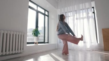 Modern dans. Geniş, boş dairenin etrafında dans eden genç bir kadın.