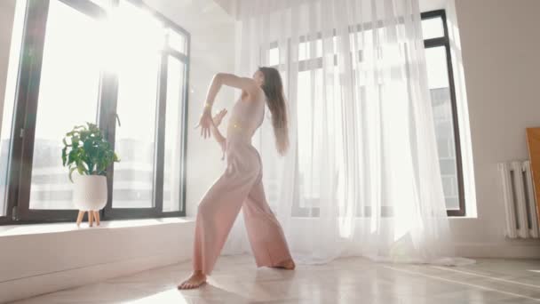 Χορός δρόμου - νεαρή λεπτή γυναίκα χορεύει σε λευκό ευρύχωρο δωμάτιο — Αρχείο Βίντεο