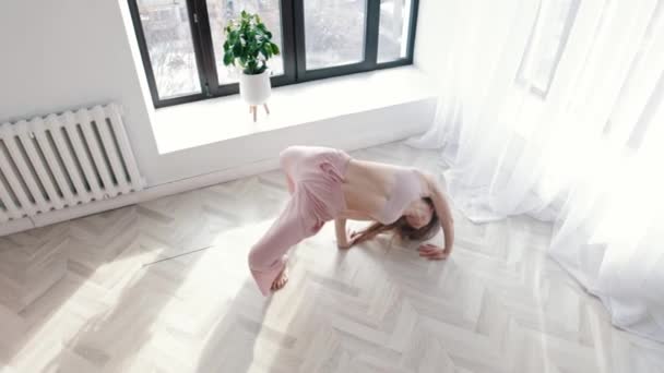 Modern dancing - young acrobatic woman dances in white spacious room by the windows — Vídeos de Stock