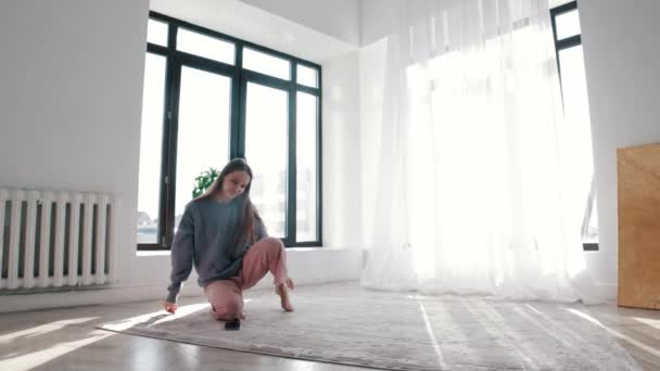 Μοντέρνος χορός - μια νεαρή γυναίκα ανοίγει τη μουσική στο τηλέφωνό της και αρχίζει να χορεύει — Αρχείο Βίντεο