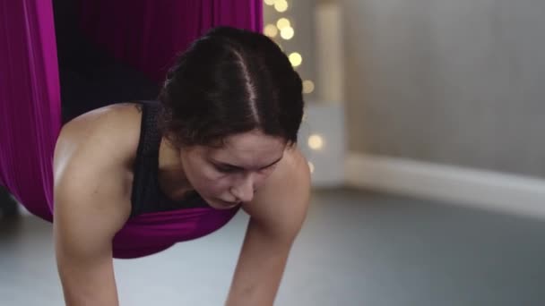 Ung kvinna som har ett flygande aerobics session och hänger på yoga hängmatta — Stockvideo