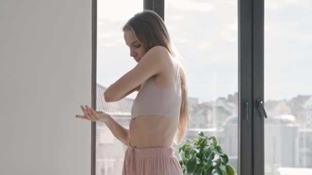 Uma jovem mulher elegante dança em um apartamento brilhante — Vídeo de Stock