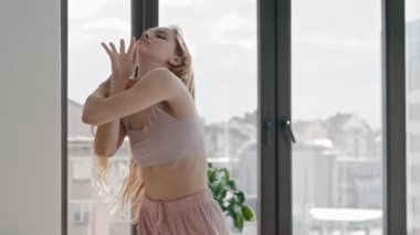 Genç plastik kadın elleriyle dans ediyor.