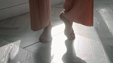Pembe pantolonlu dans eden genç kadının ayakları