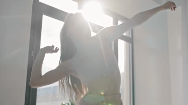 Mujer joven baila junto a la ventana — Vídeos de Stock