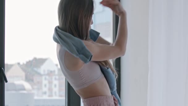 Молодая женщина танцует и заворачивается в свитер — стоковое видео