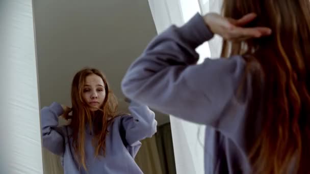 Νεαρή γυναίκα με μακριά μαλλιά χορεύει μπροστά στον καθρέφτη — Αρχείο Βίντεο