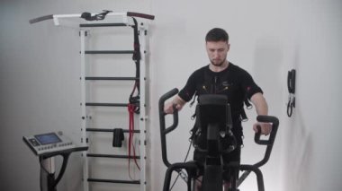 Takım elbiseli bir adam yerel spor salonunda çalışıyor.