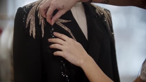 Een persoon pinnen de kraag van een jas met pailletten — Stockvideo