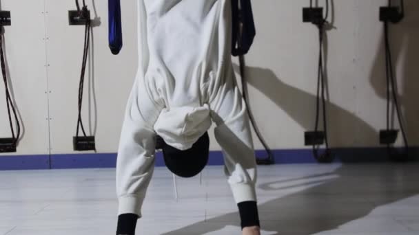 Une jeune femme en hijab et sweat à capuche blanc fait du yoga aérien — Video