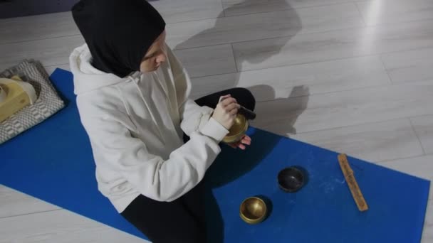 Une jeune femme en hijab fait un rituel de méditation avec de l'encens — Video