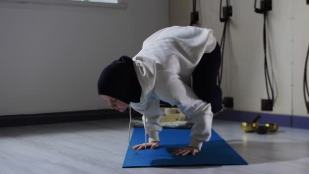 Una mujer en hijab haciendo yoga complejo en esterilla de yoga — Vídeos de Stock
