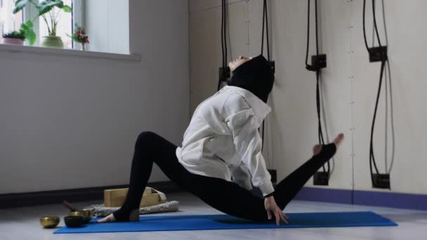 Uma mulher no hijab esticando seu corpo e fazendo ioga — Vídeo de Stock