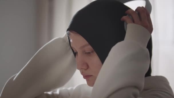 Mujer bonita en hijab se pone grandes auriculares en la cabeza — Vídeo de stock