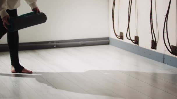 Člověk položí na podlahu podložku na jógu. — Stock video