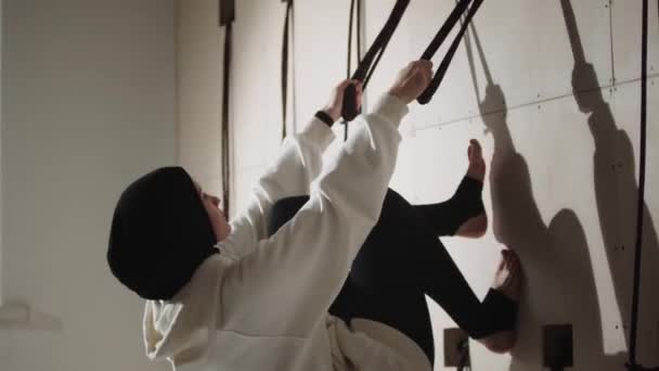 En ung kvinna i hijab håller i sina remmar och lutar kroppen mot väggen. — Stockvideo