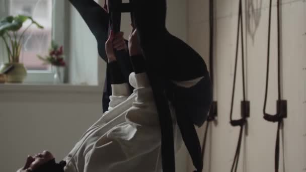 Une jeune femme dans un hijab en utilisant un hamac pour le yoga aérien — Video
