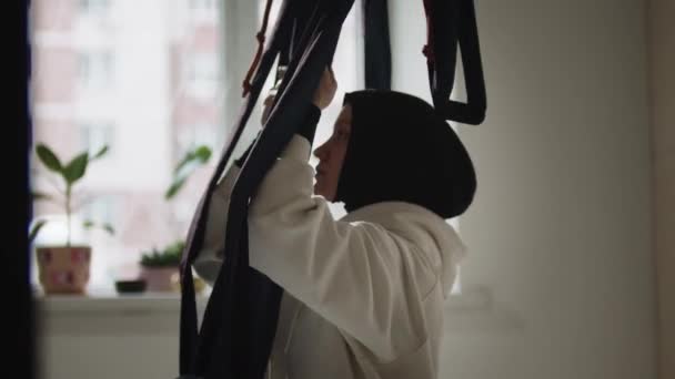 空中ヨガのためのヨガハンモックを使用してヒジャーブの女性 — ストック動画