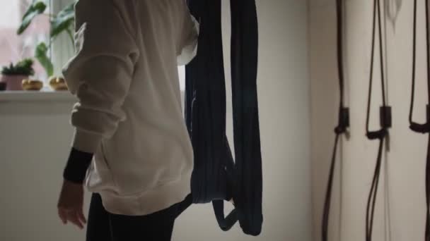 Une jeune femme dans un hijab en utilisant un hamac de yoga pour le yoga aérien en studio — Video