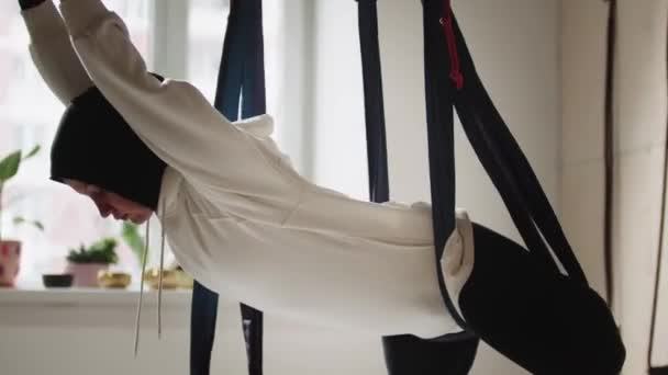 A young woman in a hijab hanging on yoga hammock in the air — Stock Video