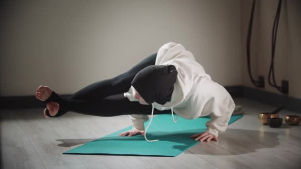 Yoga - stark kvinna i hijab gör övningar på yogamattan — Stockvideo