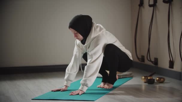 Yoga - strong woman in hijab doing exercises on yoga mat with leaning on her hands — Stock Video