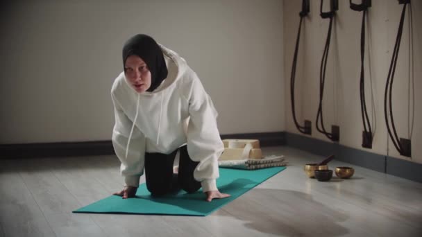 Yoga binnen - jonge vrouw in hijab staat op de plank — Stockvideo