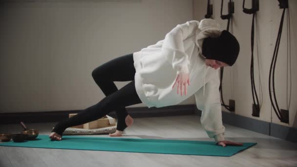 Йога - молода жінка в хіджабі робить подовжені вправи на йога маті. — стокове відео