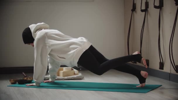Yoga - jovem mulher no hijab fazendo exercícios de alongamento no tapete de ioga cercado por objetos para meditação — Vídeo de Stock