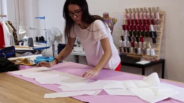 Egy fiatal nő ruhát terít az asztalra. — Stock videók