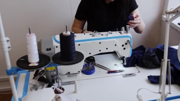 Молодая женщина готовит ткань для шитья швейной машинкой — стоковое видео