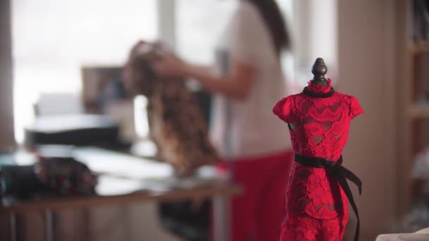 Небольшой образец платья на небольшом манекене в дизайнерской студии — стоковое видео