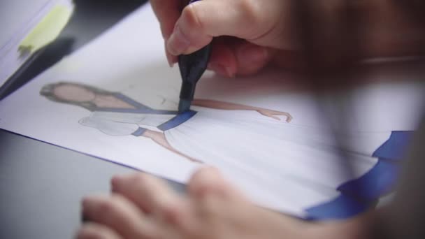 파란색 마커를 사용하여 의상 디자인을 하는 젊은 여자 — 비디오